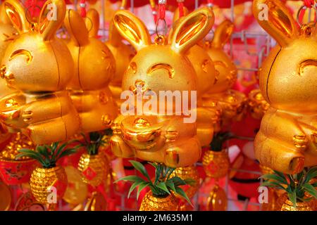 Goldkaninchen-Schmuckstücke und Schmuckstücke, verkauft auf einem Straßenmarkt, um das chinesische Neujahr des Kaninchens 2023 zu eröffnen Stockfoto