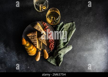 Von oben mit Käse, reifen Früchten und Beeren auf dunklem Betonhintergrund Stockfoto
