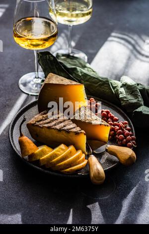 Von oben mit Käse, reifen Früchten und Beeren auf dunklem Betonhintergrund Stockfoto