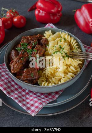 Ungarisches Gulasch mit Pasta auf einem Teller Stockfoto