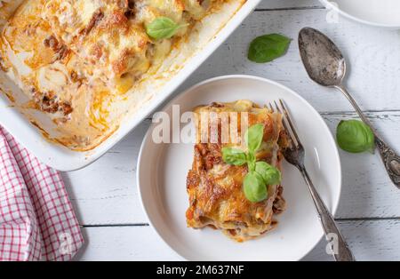 Lasagne mit Cannelloni-, Bolognese- und Béchamel-Sauce mit Mozzarella-Käse-Belag auf weißem Hintergrund. Flach verlegt Stockfoto