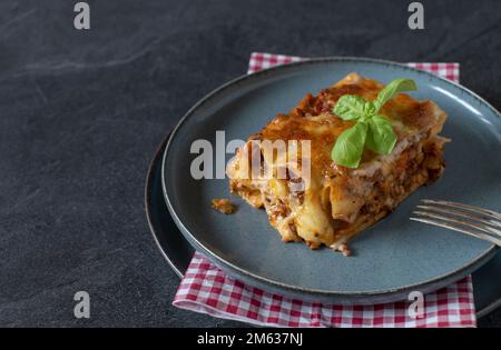 Ein Stück Nudelauflauf mit gefüllten Cannelloni. Gefüllt mit Bolognesauce und garniert mit Bocamelsauce und Mozzarella-Käse. Stockfoto