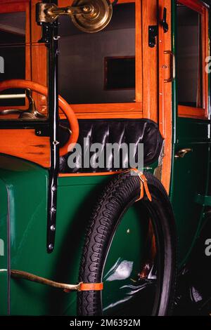 Hölzernes Lenkrad und hängender Griff in einem abgestimmten Retro-Touring-Auto mit Ledersitzen in der Garage Stockfoto