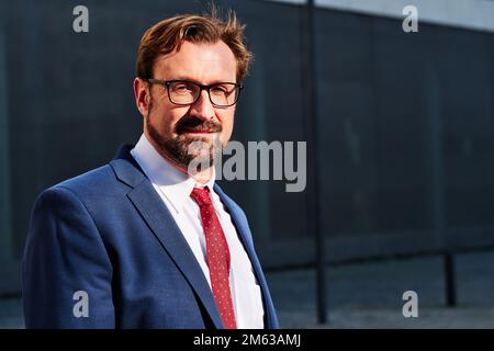 Ein Geschäftsmann, der auf der Straße in die Kamera schaut Stockfoto