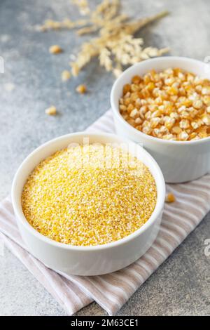 Glutenfreie Lebensmittelzutat. Grobgrieß und Samen auf grauem Steinhintergrund. Stockfoto