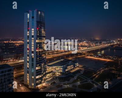 Budapest, Ungarn - Blick aus der Vogelperspektive auf den MOL Campus, Budapests neues, beleuchtetes Wolkenkratzer-Gebäude mit Rakoczi-Brücke über der Donau in der Abenddämmerung Stockfoto