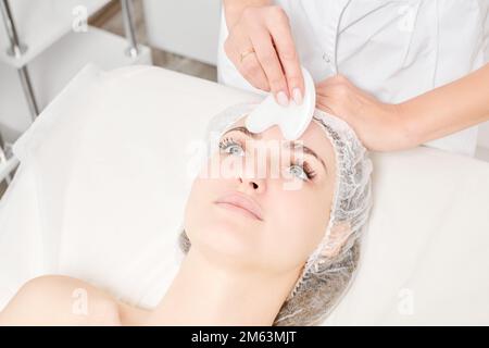 Kosmetologe macht Gesichtsmassage mit Gua Sha Stein der weiblichen Gesichtshaut für Lymphdrainage, Anti-Aging-Hautpflege kosmetische Prozedur im Beauty Spa Stockfoto