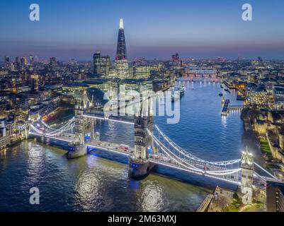Tower Bridge und The Shard, London, England, Luftaufnahme bei Nacht mit der Themse und der beleuchteten Stadtsilhouette. Stockfoto