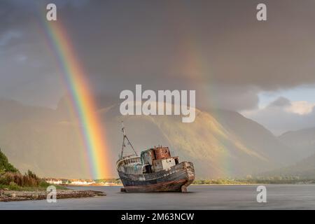 Wrack von Corpach in der Nähe von Fort William unter einem doppelten Regenbogen mit Ben Nevis und dramatischem Hochlandwetter im Hintergrund. Stockfoto