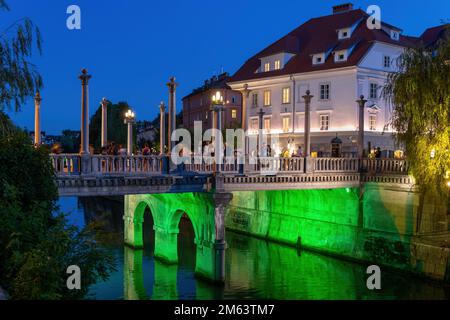 Ljubljana, Slowenien - 14. Juli 2022 - Cobblers Bridge oder Shoemakers Bridge (Sustarski Most) in der Dämmerung, Wahrzeichen der Stadt Fußgängerbrücke Stockfoto