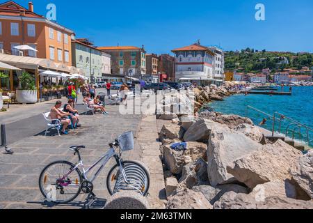 Piran, Slowenien - 20. Juli 2022: Entspannen Sie sich auf der Strandpromenade in einem Ferienort an der Adria an der südwestlichen slowenischen Küste. Stockfoto