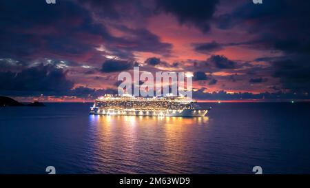 Kreuzfahrtschiff aus der Vogelperspektive mit dramatischen Wolken bei Sonnenuntergang in der Andamanensee, Phuket, Thailand Stockfoto