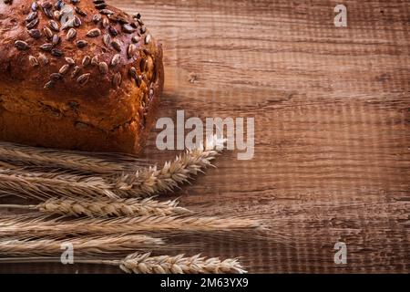 Ein Haufen Weizenohren, Brot auf Eichenholz, Essen und Trinken Stockfoto