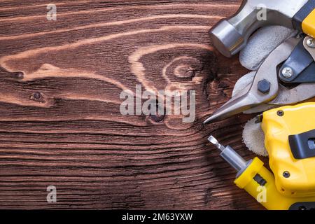 Klauenhammer Schutzhandschuh Bandschraubendreher und Zange auf Holzplatte Stockfoto