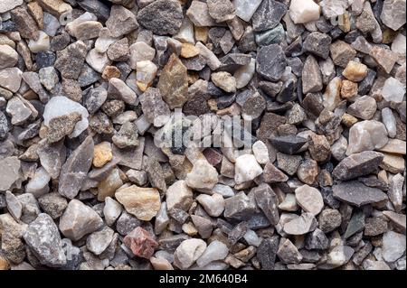 Straßen- und Putzkörnung, lose Späne, zerkleinerter Stein, Oberfläche, Makrofoto. Trockener Kalk- und eisenfreier Quarzsand, der als Streugut verwendet wird. Stockfoto