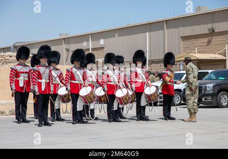 Sam Potts, Drum Major, 1. Battaltion Welsh Guards, erhält eine Münze für seine Exzellenz aus den USA Luftwaffenbrücke. Generalleutnant Brandon D. Parker, Stabschef für die kombinierte gemeinsame Task Force-Operation inhärent Resolve (CJTF-OIR) im CJTF-OIR-Komplex vom 30. März 2022 in Camp Arifjan, Kuwait. Die britische Armee unterhält ein Trommelkorps in jedem Foot Guards Bataillon. Der Zug besteht aus Wachmännern, die Trommeln und Hornwörter spielen. Mehrere Trommelkorps können bei bestimmten Anlässen „zusammengedrängt“ werden. Alle Mitglieder des Korps werden als Drummer (kurz „DMR“) r bezeichnet Stockfoto