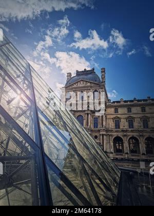 Blick auf den Louvre in Paris, Frankreich. Vertikale Aufnahme des historischen Palastgebäudes mit der modernen Glaspyramide davor Stockfoto