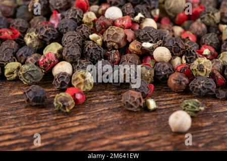 Farbige Paprika mischen sich auf dem Holzhintergrund. Stockfoto