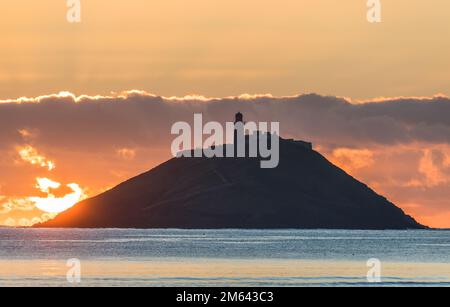 Ballycotton, Cork, Irland. 02. Januar 2023. Sonnenaufgang über der Insel und dem Leuchtturm in BallyCotton Bay, Co Cork, Irland. David Creedon/Alamy Live News Stockfoto