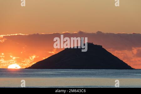 Ballycotton, Cork, Irland. 02. Januar 2023. Sonnenaufgang über der Insel und dem Leuchtturm in BallyCotton Bay, Co Cork, Irland. David Creedon/Alamy Live News Stockfoto