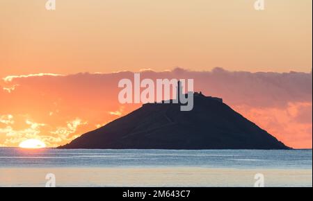 Ballycotton, Cork, Irland. 02. Januar 2023. Sonnenaufgang über der Insel und dem Leuchtturm in BallyCotton Bay, Co Cork, Irland. David Creedon/Alamy Live News Stockfoto