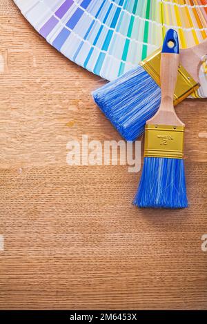 Mehrfarbige pantone-Lüfter- und Lackpinsel auf Holzbrettern – Baukonzept Stockfoto