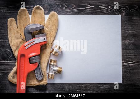 Affenschlüssel Kupferrohrfittings Leder Schutzhandschuhe weißes Papier. Stockfoto
