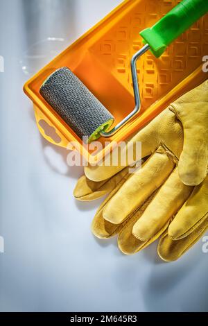 Schutzhandschuhe Farbwanne Rolle auf weißer Oberfläche. Stockfoto