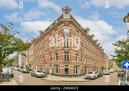 Eine Straße mit Autos, die an der Seite geparkt sind, und Gebäude in der Mitte der Straße, alle versteinert Stockfoto