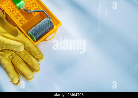 Sicherheitshandschuhe Farbwanne Rolle auf weißer Oberfläche. Stockfoto