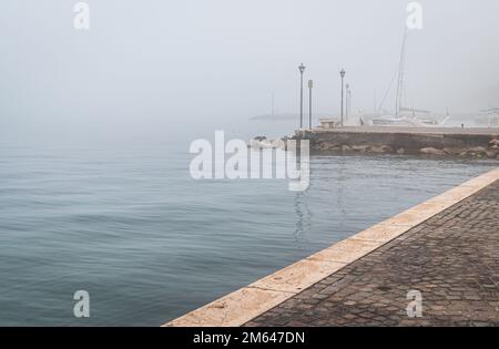 Alter Hafen der kleinen und malerischen Stadt Lazise am Gardasee in der Wintersaison. Lazise, Provinz Verona, Norditalien, Europa Stockfoto