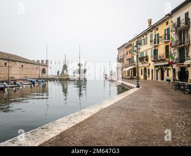 Alter Hafen der kleinen und malerischen Stadt Lazise am Gardasee in der Wintersaison. Lazise, Provinz Verona, Norditalien - Europa Stockfoto