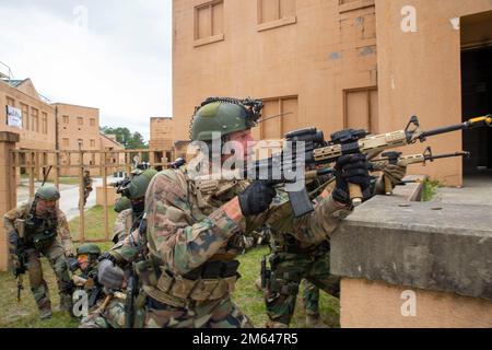 Die niederländischen Marines mit der Marinegeschwader Carib erhalten während einer militärischen Operation in Urban Terrain Training Übung, Camp Lejeune, N.C., 31. März 2022 simuliertes feindliches Feuer. Diese Marines führten Trainingsszenarien durch, um ihre Fähigkeiten und Koordination in einem städtischen Umfeld zu verbessern und gleichzeitig zur Interdependenz mit Verbündeten und Partnern beizutragen. Camp Lejeune, niederländische Marines, MOUT, Marine Squadron Carib, Marines, Stockfoto