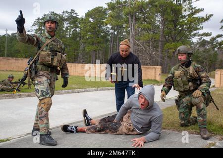 Niederländische Marines mit Marinegeschwader Carib helfen einem simulierten verletzten Zivilisten während eines Trainings für Military Operations in Urban Terrain (MOUT) in Camp Lejeune, N.C., 31. März 2022. Diese Marines führten Trainingsszenarien durch, um ihre Fähigkeiten und ihre Koordination in einem städtischen Umfeld zu verbessern und zur Interdependenz mit Verbündeten und Partnern beizutragen. Camp Lejeune, niederländische Marines, MOUT, Marine Squadron Carib, Marines, Stockfoto