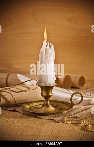 Blick auf die brennende Kerze mit alten Noten Blatt Stockfoto