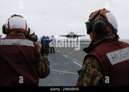 220331-N-CM110-1058 PAZIFISCHER OZEAN (MÄRZ 31, 2022) – Marineinfanteristen der Marine Aircraft Group 13 (MAG13) mit Sitz in Yuma, Arizona, beobachten, wie ein F-35B Lightning-Flugzeug an Bord des amphibischen Sturmschiffs USS Tripoli (LHA 7) über das Flugdeck taxiert, März 31. VMX-1 wird an Bord von Tripolis als Teil der U.S. Marine Corps "Lightning Carrier Concept Demonstration. Die Lightning Carrier Concept Demonstration zeigt, dass Tripolis und andere amphibische Angriffsschiffe in der Lage sind, als dedizierte stationäre Trägerplattformen zu arbeiten, die in der Lage sind, kurze Starts-/Vertikal-Landing-Luft der fünften Generation zu bringen Stockfoto