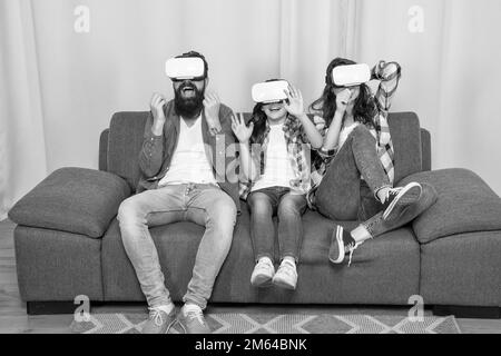 Glad Familie tragen vr Gläser sitzen auf dem Sofa zu Hause, zukünftige Technologie Stockfoto