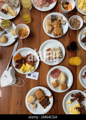 Der Tisch war zum Frühstück mit Tellern gefüllt Stockfoto