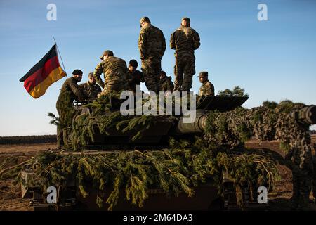 USA Soldaten mit 3. Bataillon, 66. Panzerregiment, 1. Infanteriedivision, sprechen mit einem deutschen Soldaten, während sie auf einem deutschen Panzer sitzen, als Teil einer statischen Ausstellung am Pabrade Training Area, Litauen, 31. März 2022. Mitglieder der Nordatlantischen Allianz, die an der Veranstaltung teilgenommen haben, zeigten einige ihrer Fähigkeiten zum Truppenschutz, um ihre Verbündeten von ihrem Einsatz für ihre gemeinsame Verteidigung zu überzeugen. Stockfoto