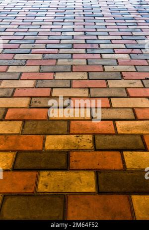 Ein Teil des Gehwegs besteht aus farbigen Pflastersteinen. Stockfoto