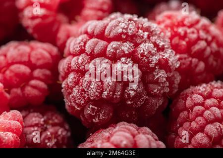 Gefrorene Himbeeren, bedeckt mit Heiserfrost. Nahaufnahme. Stockfoto