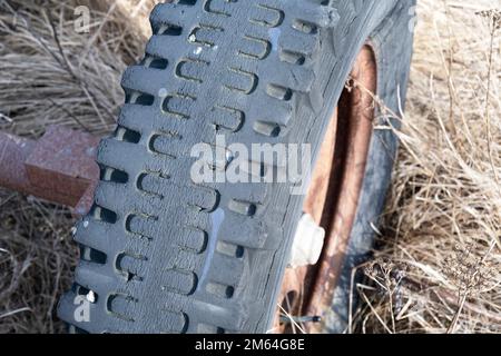 Alter Gummireifen auf einem rostigen Rad Stockfoto