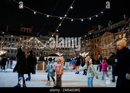 Glückliche Leute, die mitten in der Altstadt von Warschau in Polen Schlittschuhlaufen. Stockfoto