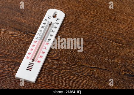 Thermometer zur Messung der Lufttemperatur auf Holzhintergrund Stockfoto