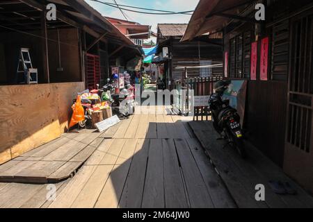 Georgetown, Penang, Malaysia - November 2012: Ein hölzerner Fußweg durch traditionelle Pfahlbauten in den Clan-Anlegestegen eines am Wasser gelegenen Dorfes in George T. Stockfoto