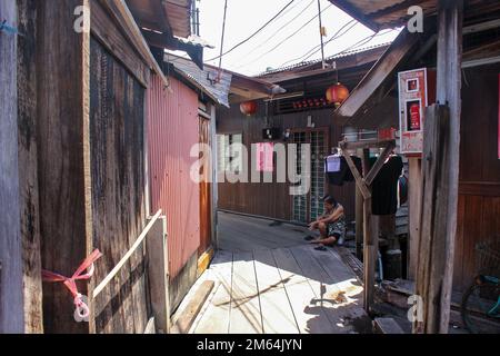 Georgetown, Penang, Malaysia - November 2012: Ein hölzerner Fußweg durch traditionelle Pfahlbauten in den Clan-Anlegestegen eines am Wasser gelegenen Dorfes in George T. Stockfoto