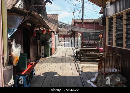 Georgetown, Penang, Malaysia - November 2012: Ein hölzerner Fußweg durch traditionelle Pfahlbauten in den Clan-Anlegestegen eines am Wasser gelegenen Dorfes in George T. Stockfoto