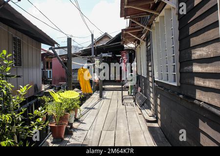 Georgetown, Penang, Malaysia - November 2012: Ein hölzerner Fußweg durch traditionelle Pfahlbauten in den Clan-Anlegestegen eines am Wasser gelegenen Dorfes in George T. Stockfoto