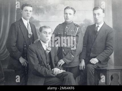 Eine Gruppe von Freunden, darunter ein britischer Armeesoldat in der Royal Field Artillery mit einem Abzeichen und Medaillenbändern für die British war Medal und Victory Medal. 03/11/1919. Stockfoto