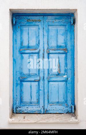 Santorin Griechenland, verblasste alte rustikale blaue Tür auf der Insel Santorin Griechenland, traditionelle griechische Farben Sonnenlicht verblassen Tourismus griechische Inseln Stockfoto